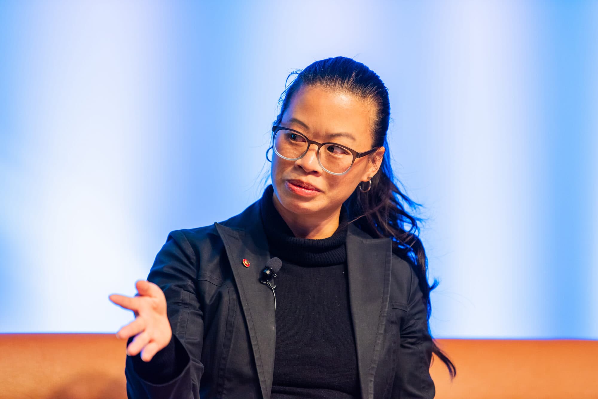 Evelyn Lee gesturing during a fireside chat at AIA Colorado.
